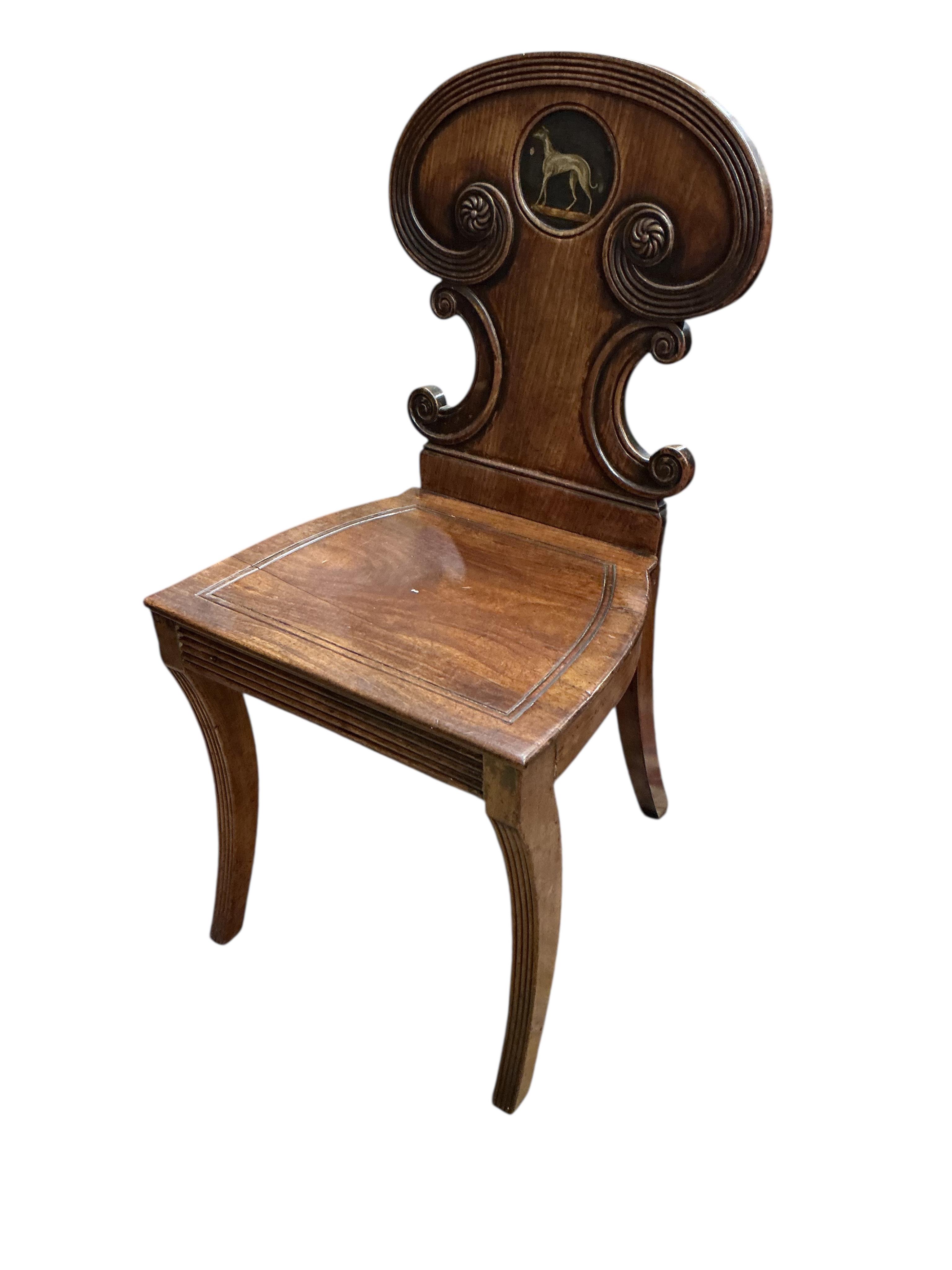 A Regency mahogany hall chair with painted greyhound armorial, height 83cm